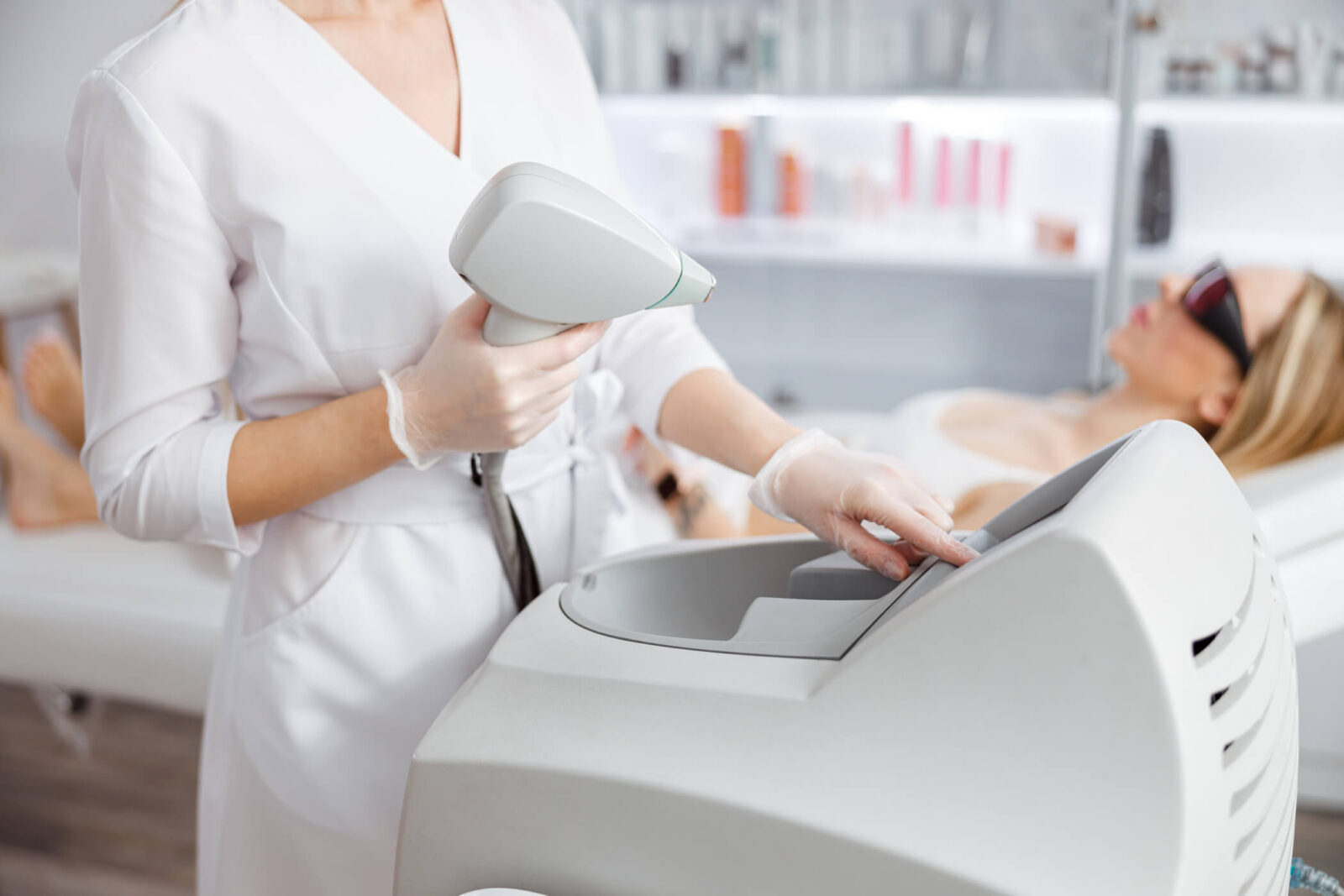 Woman beautician using laser epilation machine in beauty salon