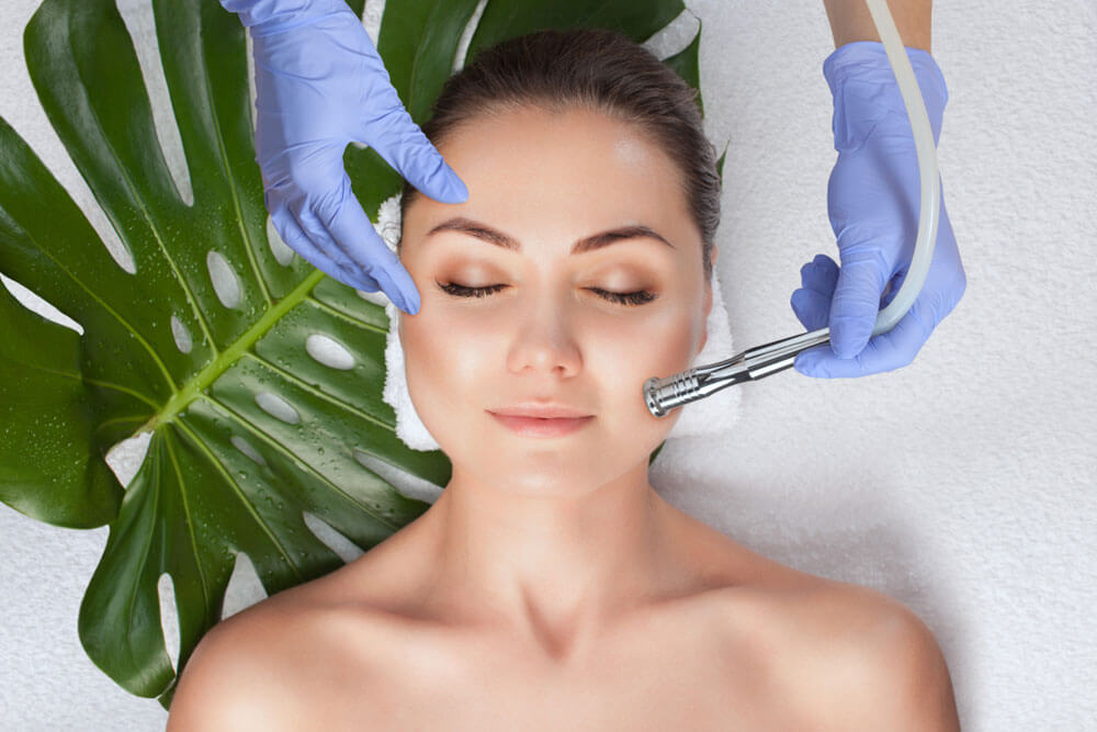 The cosmetologist makes the Microdermabrasion procedure of the facial skin