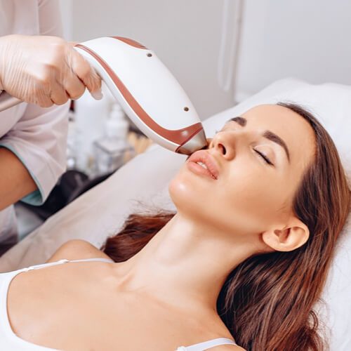 A young beautiful woman lies on a couch and gets a spa treatment